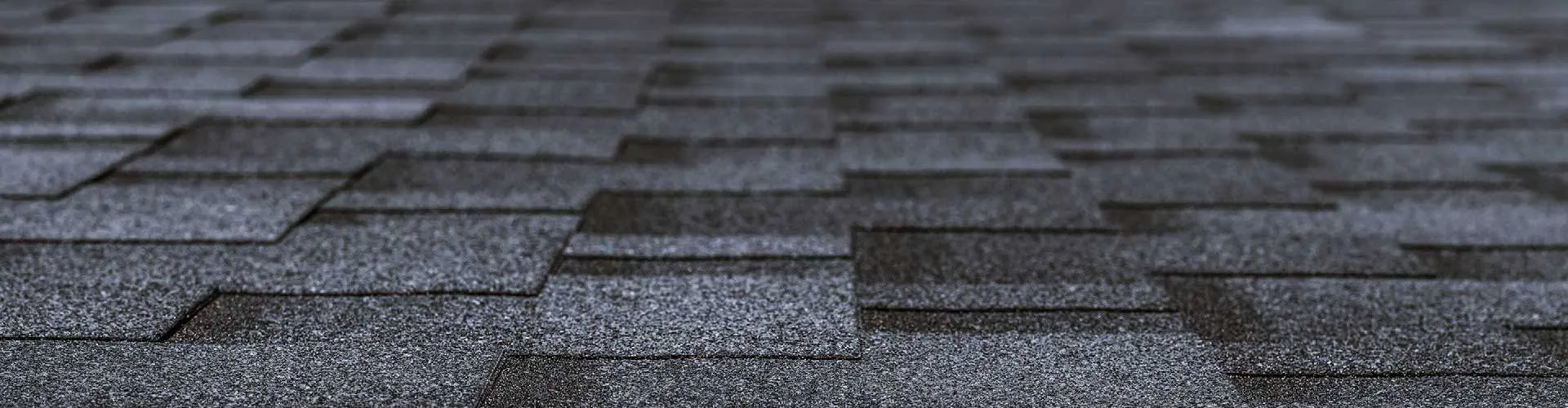 Rows of grey asphalt shingles on a roof