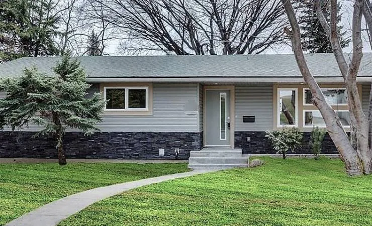 Bungalow with a new grey shingle roof and a front lawn