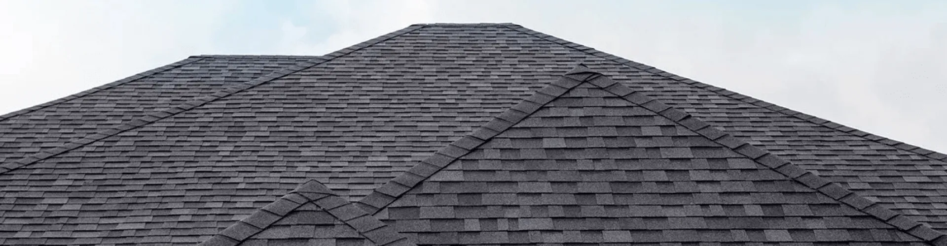 New grey asphalt shingle roof with hip ridges