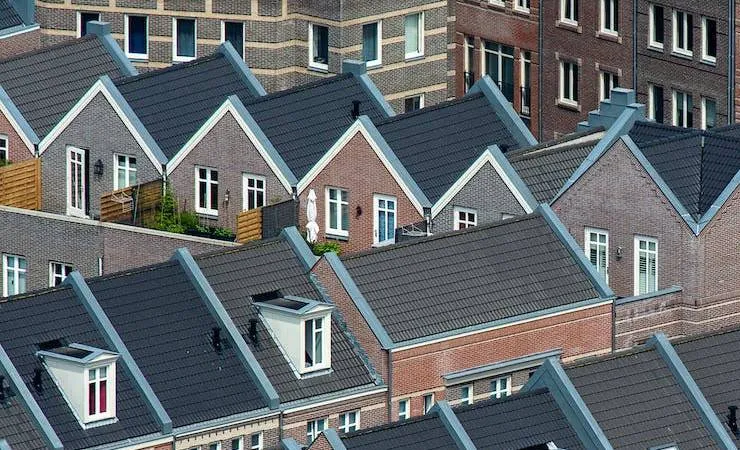Rows of townhouse roofs with dark roofing seen from above
