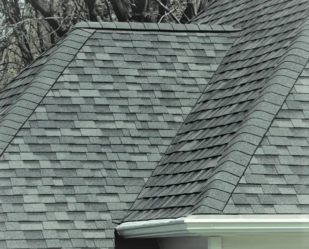 Grey shingle hip roof above a white eavestrough