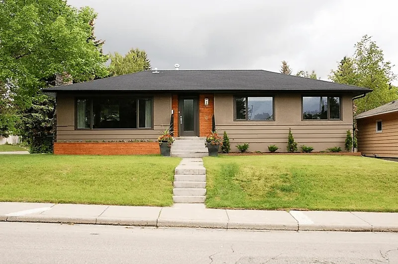 Bungalow with a dark shingle roof, seen from the street
