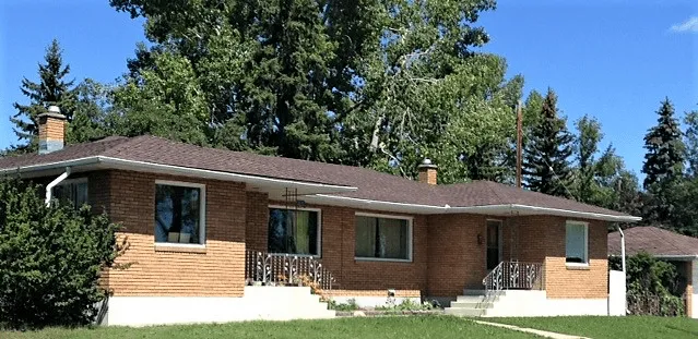 Brick bungalow with a brown shingle roof