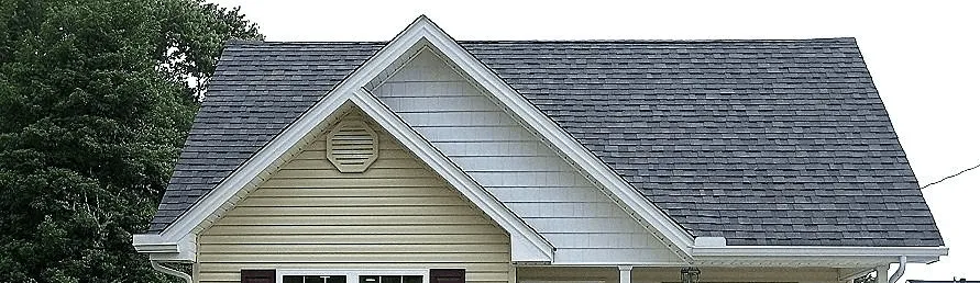 House gable with a dark grey shingle roof and white trim