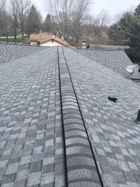 Grey shingle roof with a ridge vent along the peak