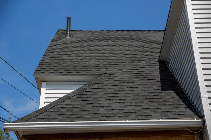 Shingle roof over a home with white siding